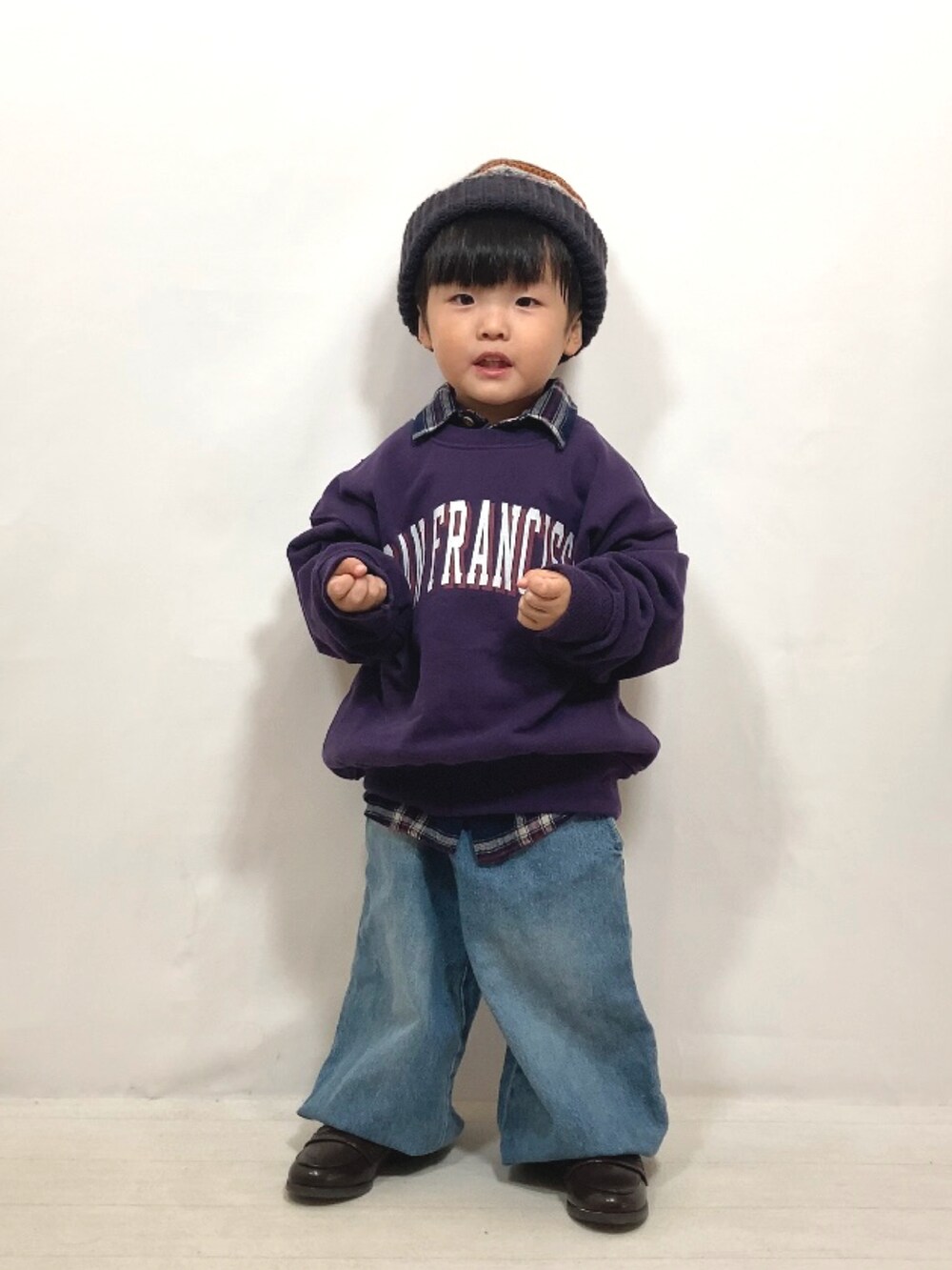 パープル系のスウェット、ブルー系のシャツ/ブラウス、ブルー系のデニムパンツを着用したキッズの秋コーディネートの2枚目の写真