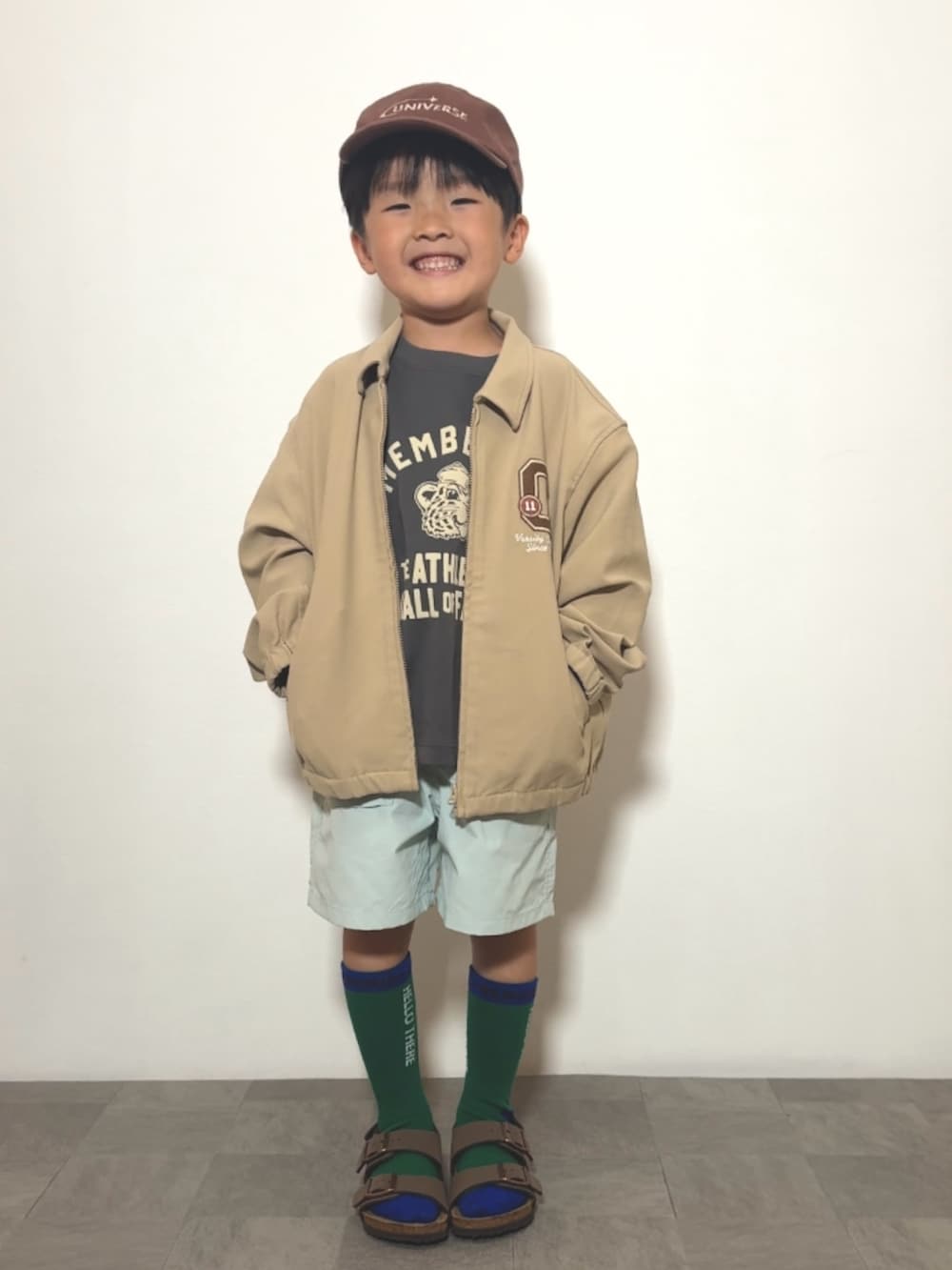 ブラウン系のサンダル、グレー系のTシャツ/カットソー、ベージュ系のジャケット/アウターを着用したキッズの春コーディネートの2枚目の写真