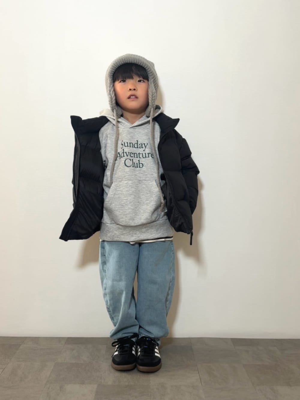 ブラック系のスニーカー、グレー系のパーカー、ホワイト系のトップスを着用したキッズの冬コーディネートの2枚目の写真