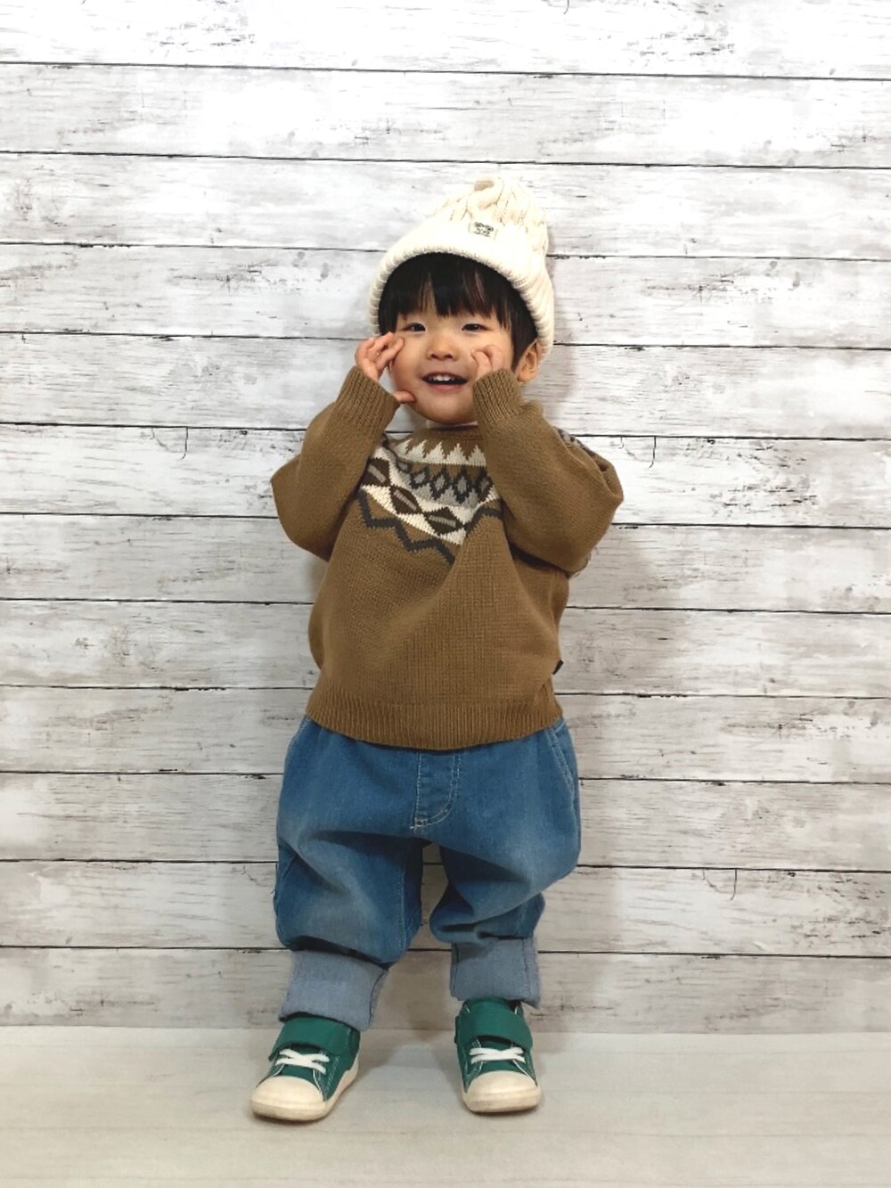 ブラウン系のニット/セーター、ホワイト系のTシャツ/カットソー、ブルー系のデニムパンツを着用したキッズの冬コーディネートの2枚目の写真