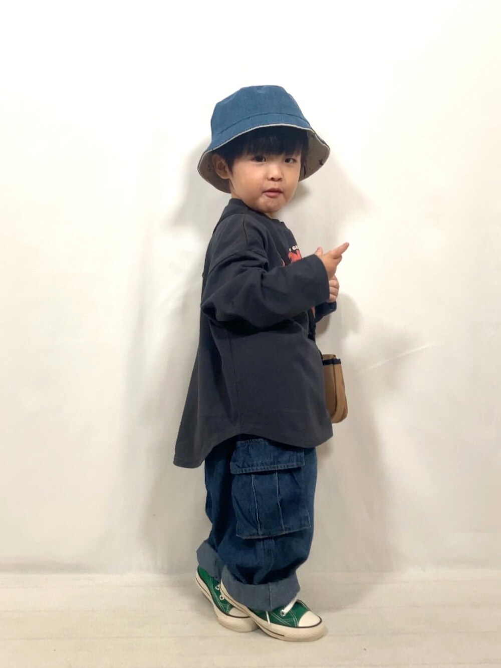 グレー系のトップス、ブルー系のデニムパンツ、イエロー系のショルダーバッグを着用したキッズの秋コーディネートの5枚目の写真