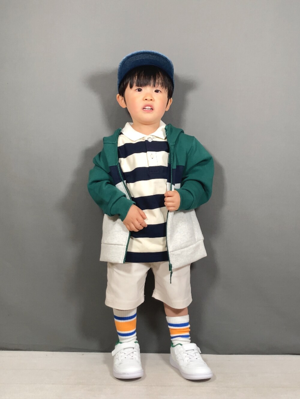 グリーン系のパーカー、ベージュ系のトップス、ホワイト系のその他パンツを着用したキッズの春コーディネートの2枚目の写真