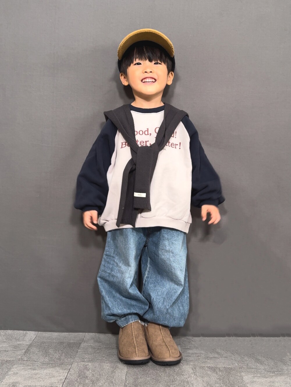 グレー系のスウェット、ブルー系のデニムパンツ、イエロー系のブーツを着用したキッズの冬コーディネートの3枚目の写真