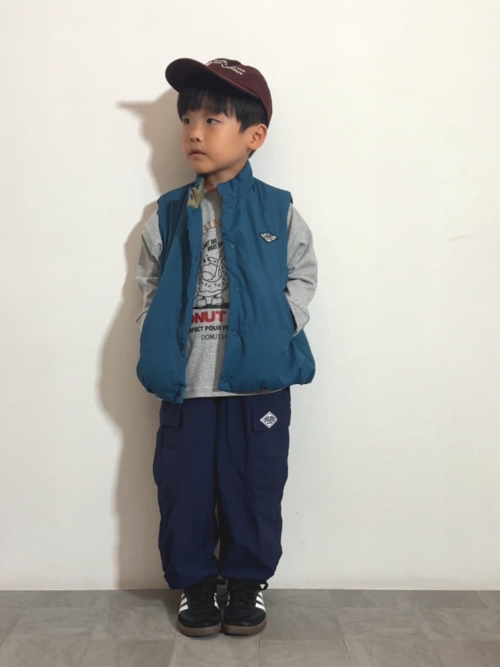 ブラック系のスニーカー、グレー系のTシャツ/カットソー、ブルー系のカーゴパンツを着用したキッズの秋コーディネートの2枚目の写真