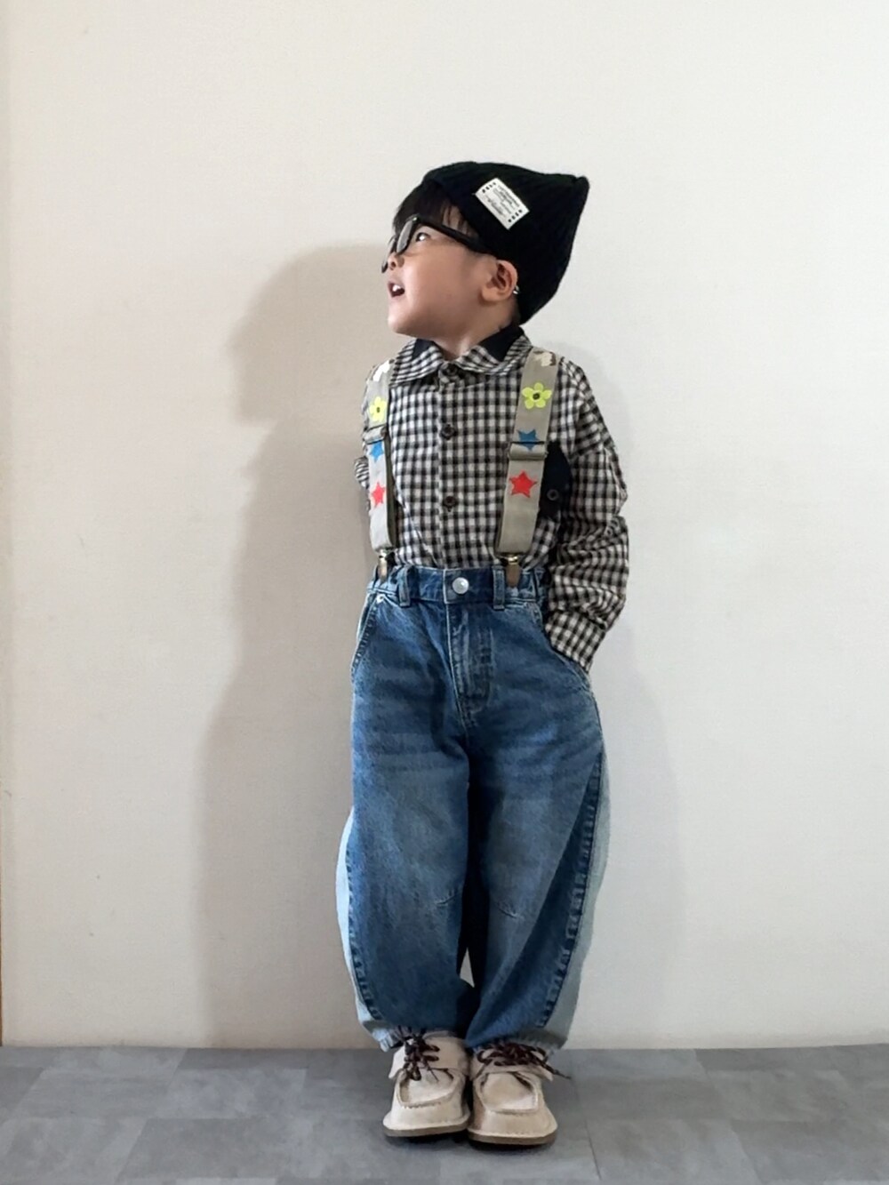 ブラック系のシャツ/ブラウス、ベージュ系のモカシン/デッキシューズ、ブルー系のデニムパンツを着用したキッズの秋コーディネートの3枚目の写真