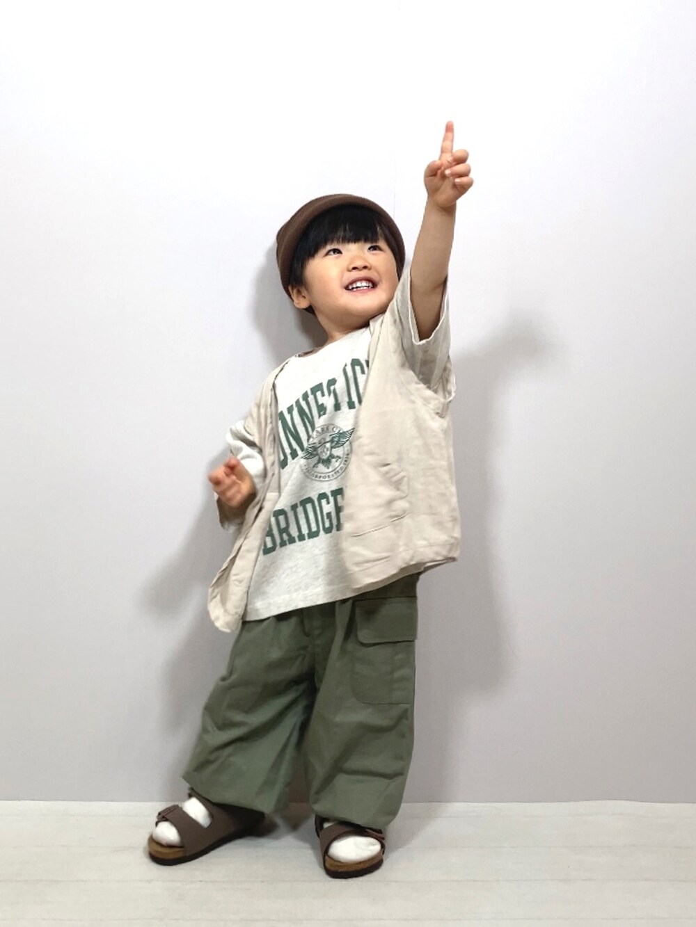 グレー系のTシャツ/カットソー、ホワイト系のベスト、グリーン系のカーゴパンツを着用したキッズの春コーディネートの3枚目の写真