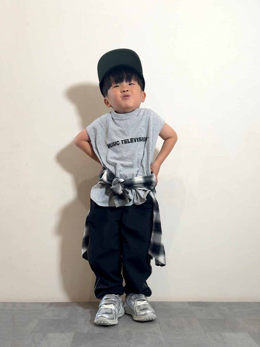 グレー系のタンクトップ、シルバー系のスニーカー、ブラック系のシャツ/ブラウスを着用したキッズの夏コーディネートの2枚目の写真