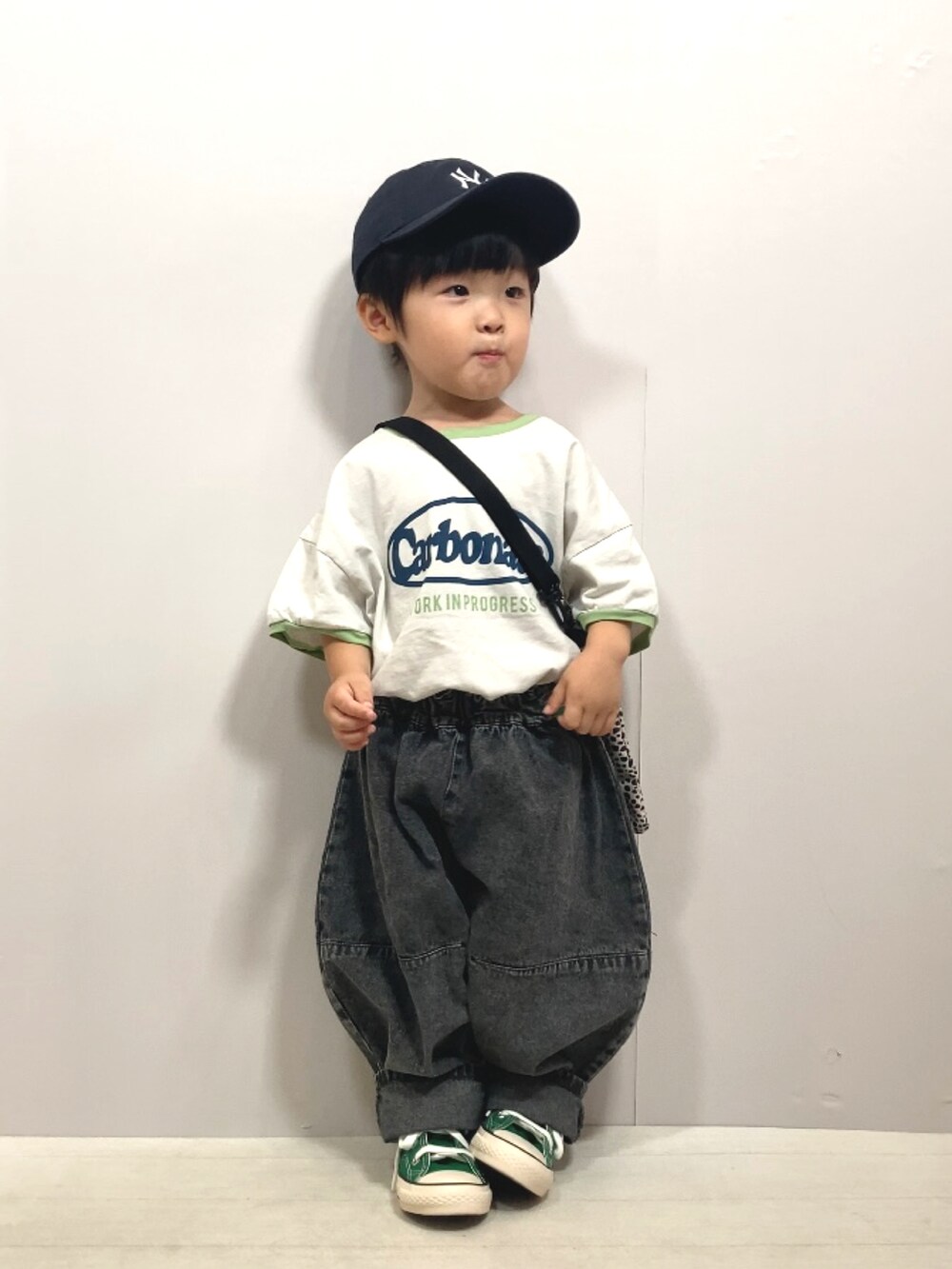 グレー系のTシャツ/カットソー、ブラック系のデニムパンツ、ベージュ系のショルダーバッグを着用したキッズの夏コーディネートの4枚目の写真