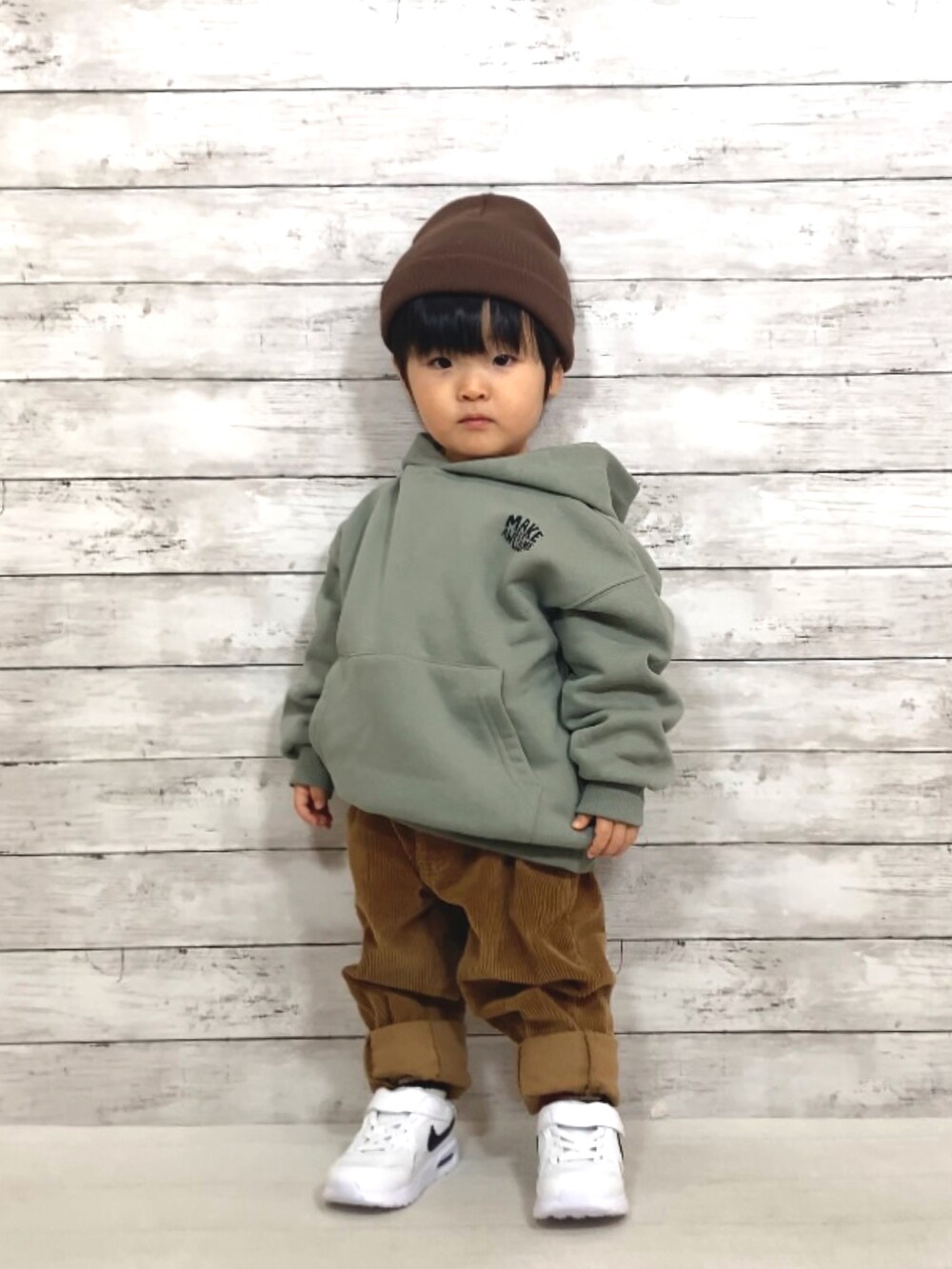 グリーン系のスウェット、イエロー系のその他パンツ、ホワイト系のスニーカーを着用したキッズの冬コーディネートの2枚目の写真