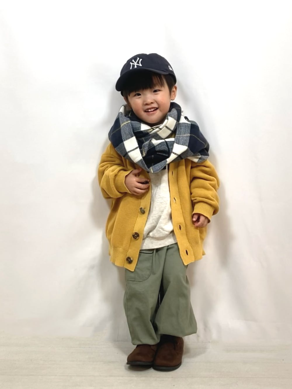 イエロー系のカーディガン/ボレロ、グレー系のスウェット、グリーン系のカーゴパンツを着用したキッズの秋コーディネートの5枚目の写真