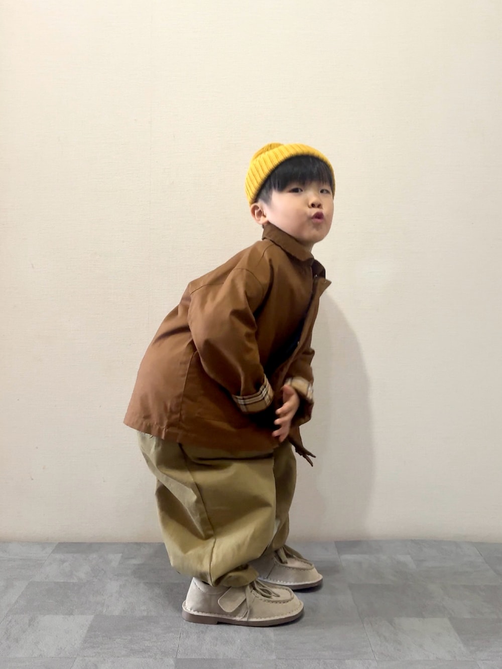 ブラウン系のその他パンツ、ベージュ系のモカシン/デッキシューズ、グリーン系のTシャツ/カットソーを着用したキッズの秋コーディネートの3枚目の写真