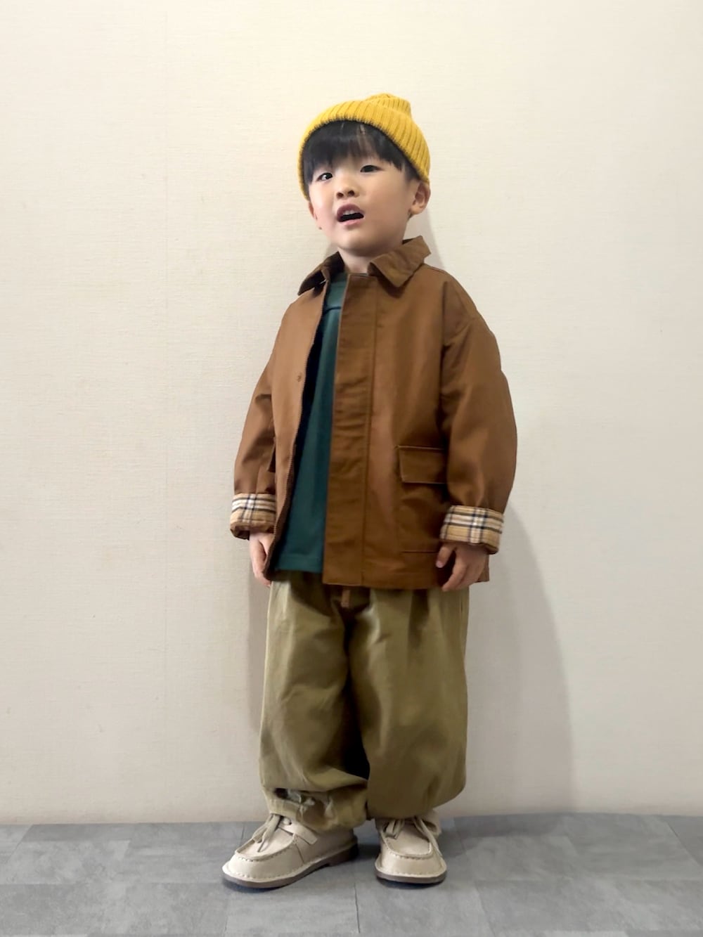 ブラウン系のその他パンツ、ベージュ系のモカシン/デッキシューズ、グリーン系のTシャツ/カットソーを着用したキッズの秋コーディネートの2枚目の写真