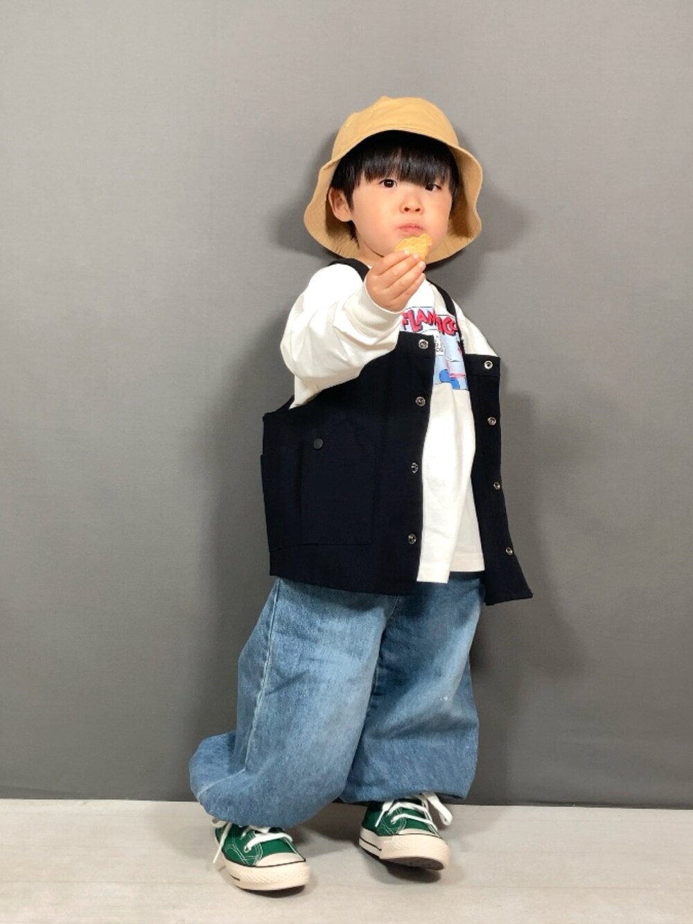 ブラック系のベスト、ホワイト系のTシャツ/カットソー、ブルー系のデニムパンツを着用したキッズの春コーディネートの2枚目の写真