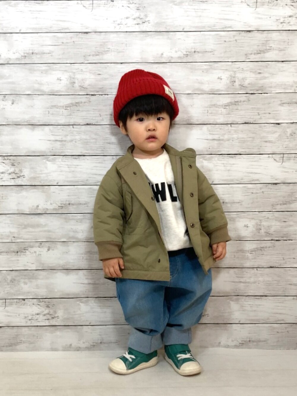 グリーン系のダウンジャケット/コート、グレー系のスウェット、ブルー系のデニムパンツを着用したキッズの秋コーディネートの3枚目の写真