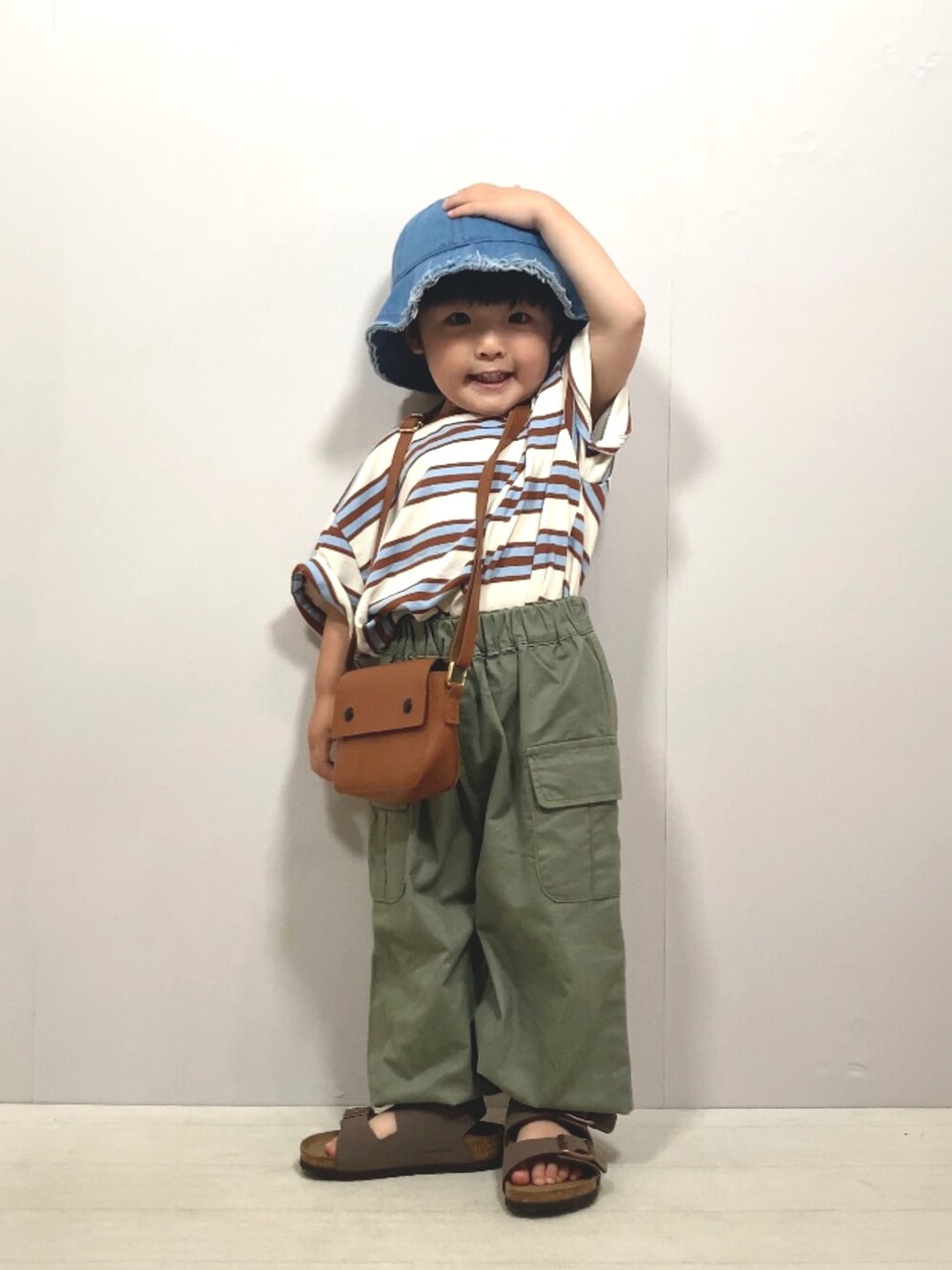 ベージュ系のTシャツ/カットソー、グリーン系のカーゴパンツ、ブラウン系のショルダーバッグを着用したキッズの夏コーディネートの3枚目の写真