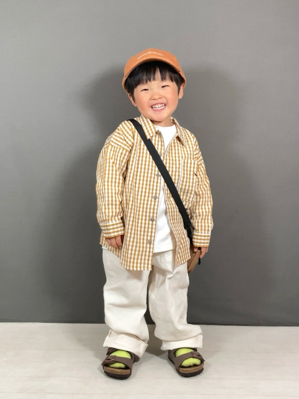 イエロー系のシャツ/ブラウス、グリーン系のTシャツ/カットソー、ホワイト系のパンツを着用したキッズの春コーディネートの3枚目の写真