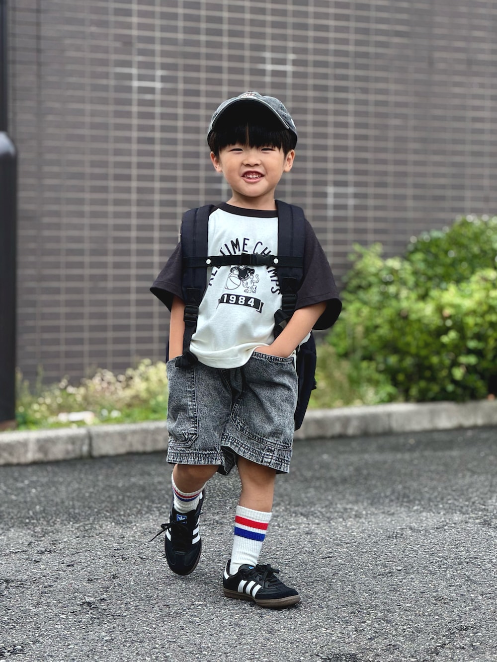 ベージュ系のTシャツ/カットソー、ブラック系のデニムパンツ、ブラック系のバックパック/リュックを着用したキッズの夏コーディネートの4枚目の写真