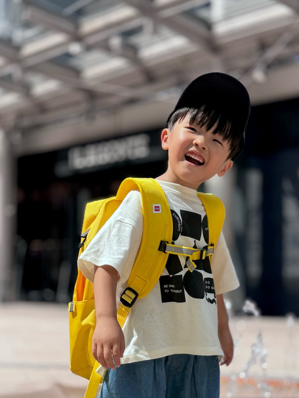 ブラック系のTシャツ/カットソー、ブルー系のその他パンツ、イエロー系のバックパック/リュックを着用したキッズの秋コーディネートの3枚目の写真