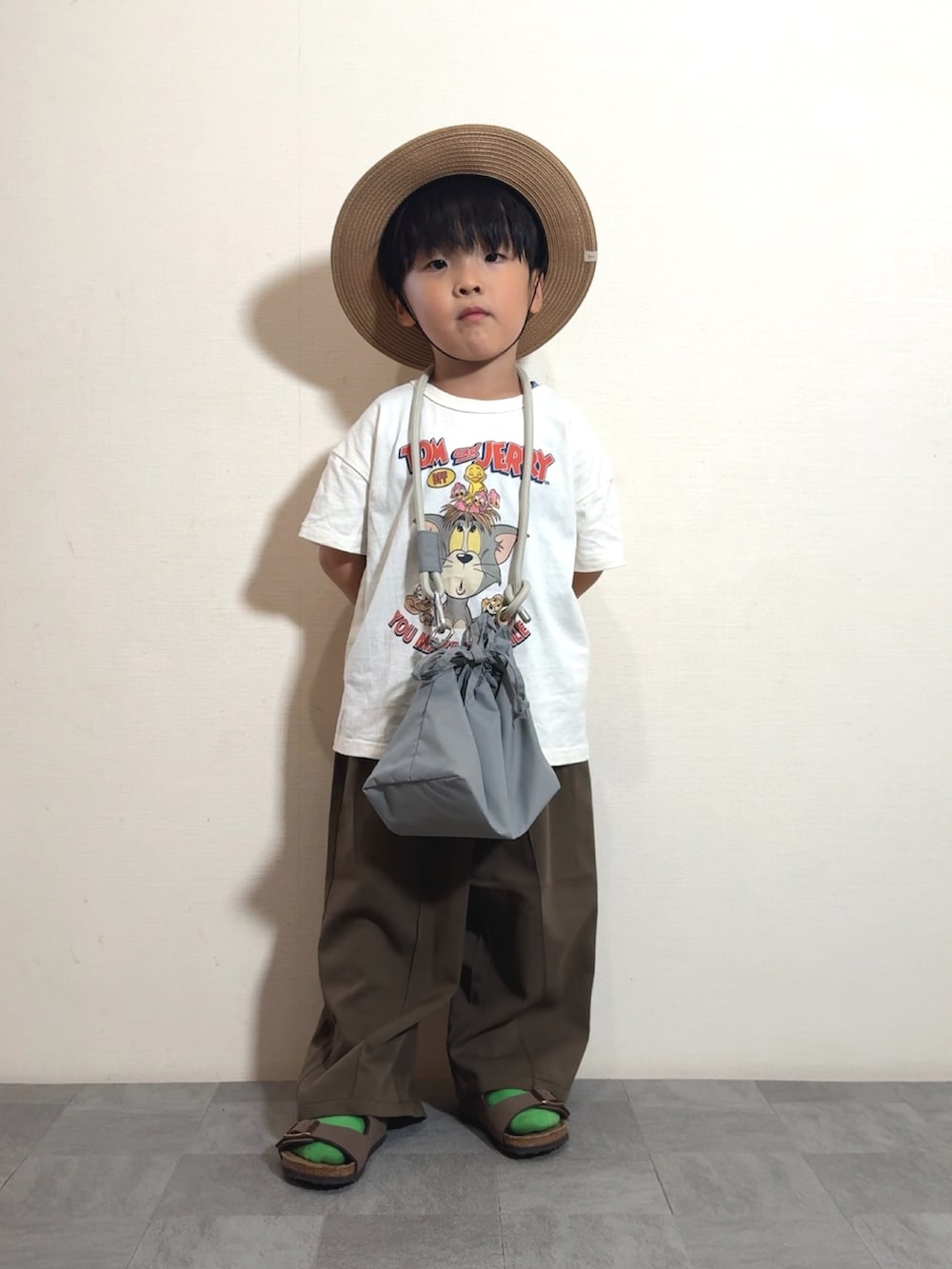 ホワイト系のTシャツ/カットソー、グレー系のショルダーバッグ、ブラウン系のスラックスを着用したキッズの夏コーディネートの4枚目の写真