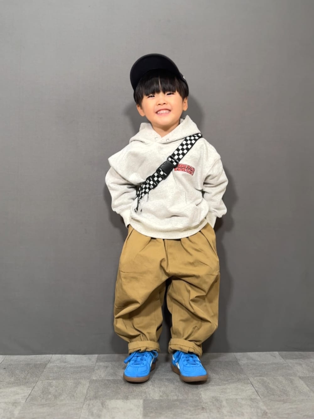 グレー系のスウェット、ブラウン系のその他パンツ、イエロー系のショルダーバッグを着用したキッズの冬コーディネートの3枚目の写真