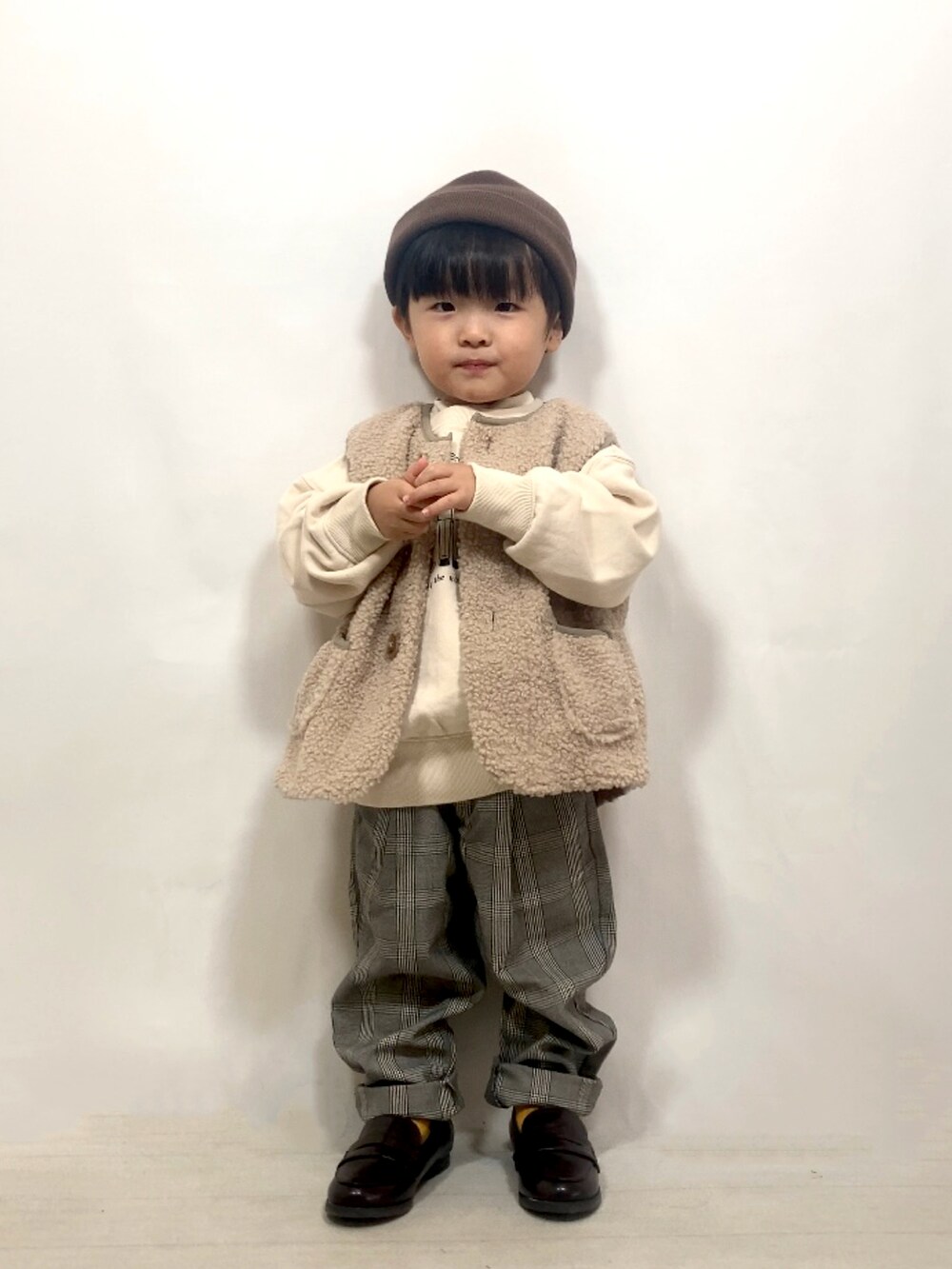 ベージュ系のベスト、ベージュ系のスウェット、ホワイト系のTシャツ/カットソーを着用したキッズの秋コーディネートの4枚目の写真