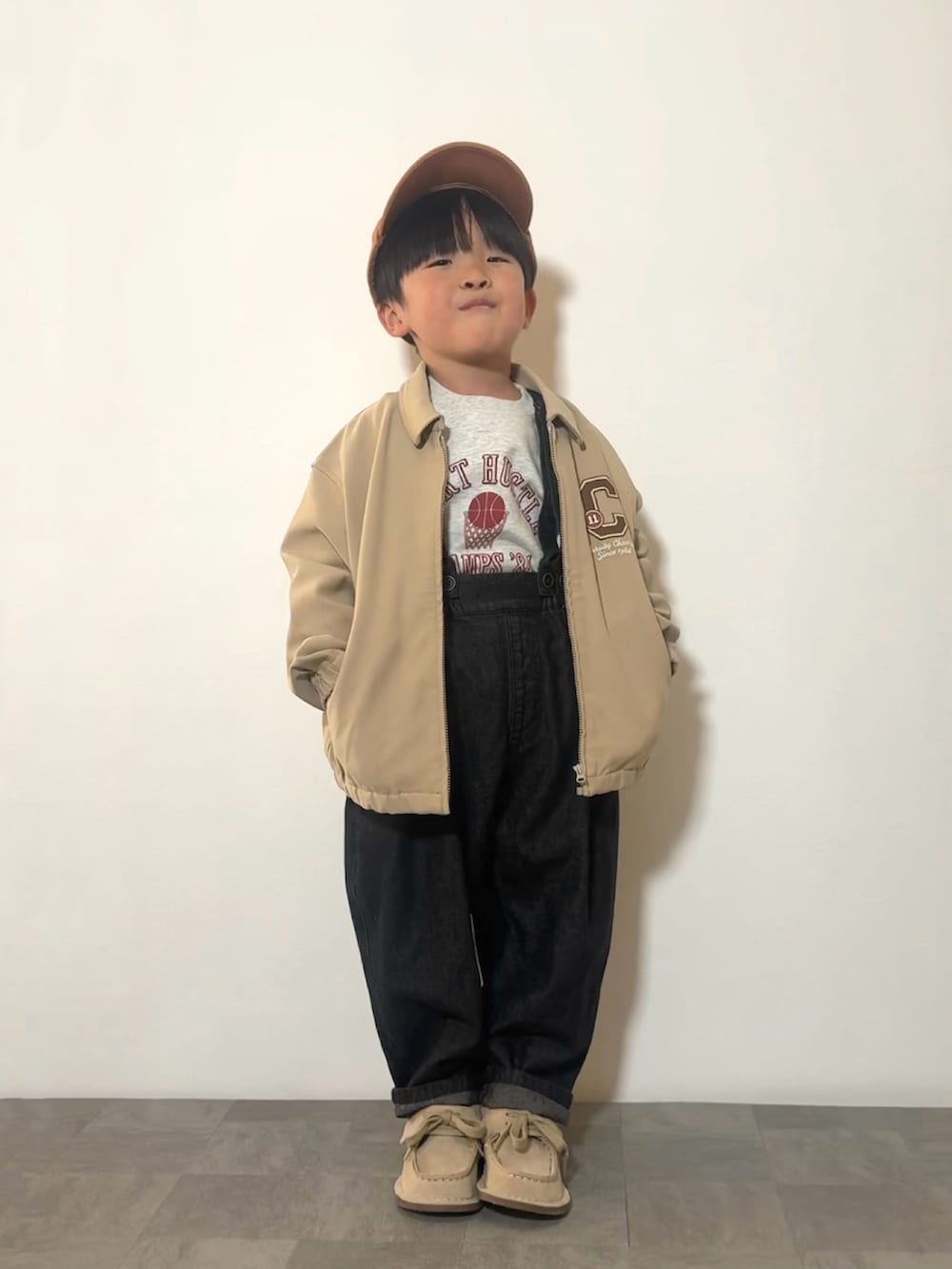 ブラック系のサロペット/オーバーオール、ベージュ系のモカシン/デッキシューズ、グレー系のスウェットを着用したキッズの冬コーディネートの3枚目の写真