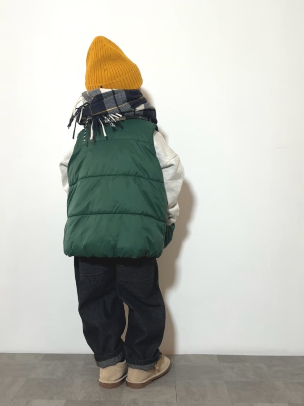 グレー系のスウェット、ブラック系のサロペット/オーバーオール、ベージュ系のモカシン/デッキシューズを着用したキッズの冬コーディネートの3枚目の写真