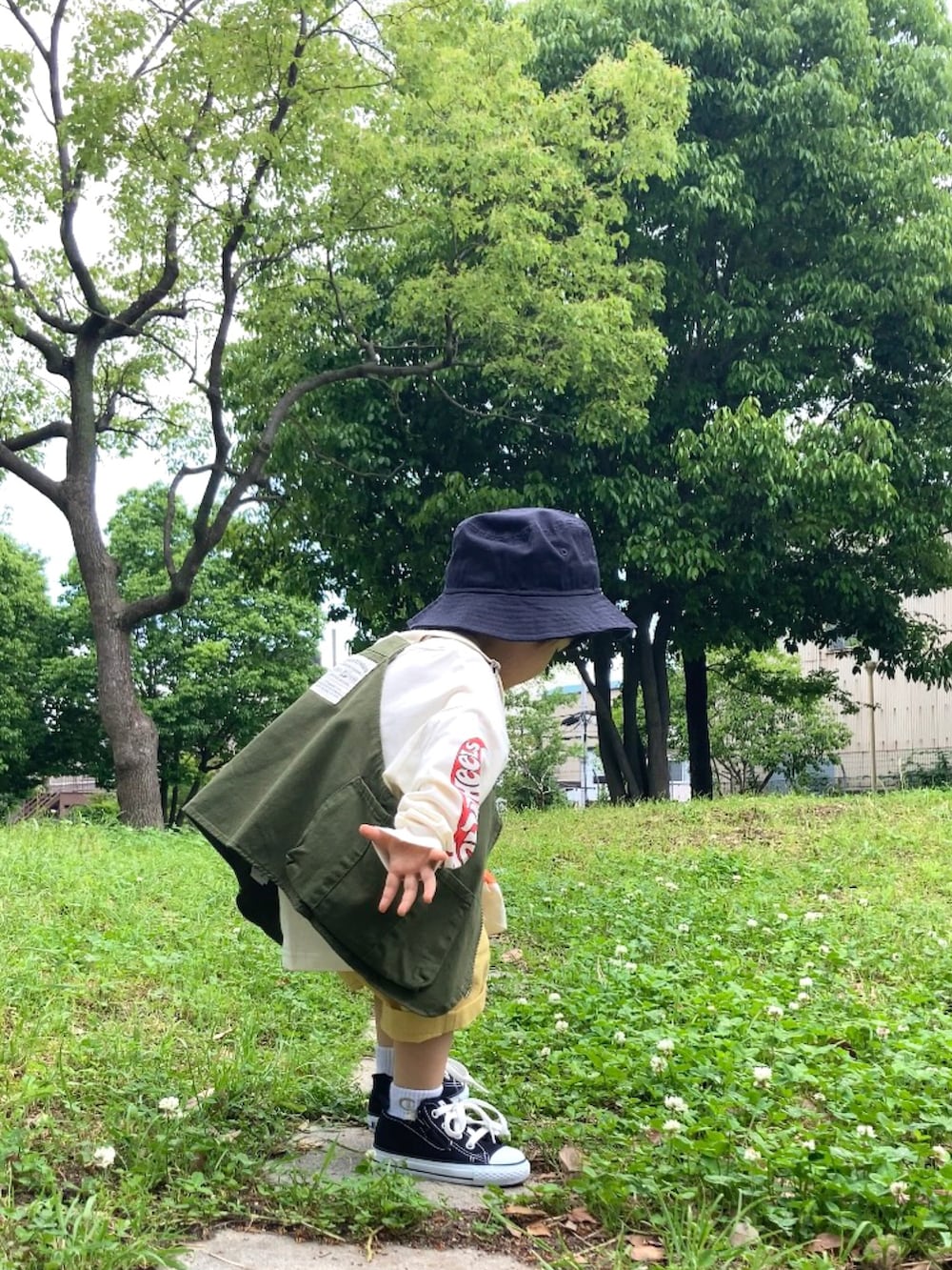 グリーン系のベスト、ホワイト系のTシャツ/カットソー、イエロー系のパンツを着用したキッズの春コーディネートの4枚目の写真