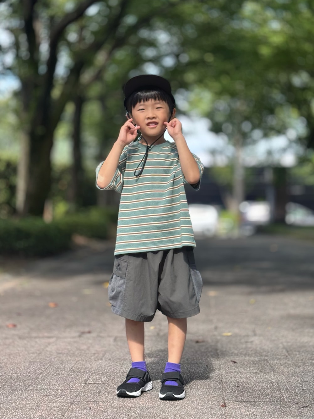 グリーン系のTシャツ/カットソー、ブラック系のサンダル、グレー系のその他パンツを着用したキッズの夏コーディネートの2枚目の写真