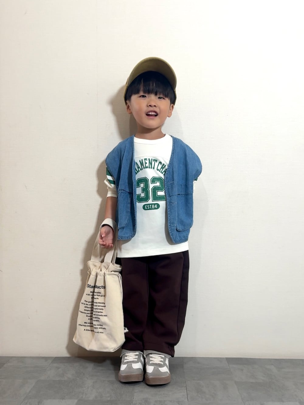 ブルー系のベスト、ホワイト系のトップス、ブラウン系のパンツを着用したキッズの夏コーディネートの2枚目の写真