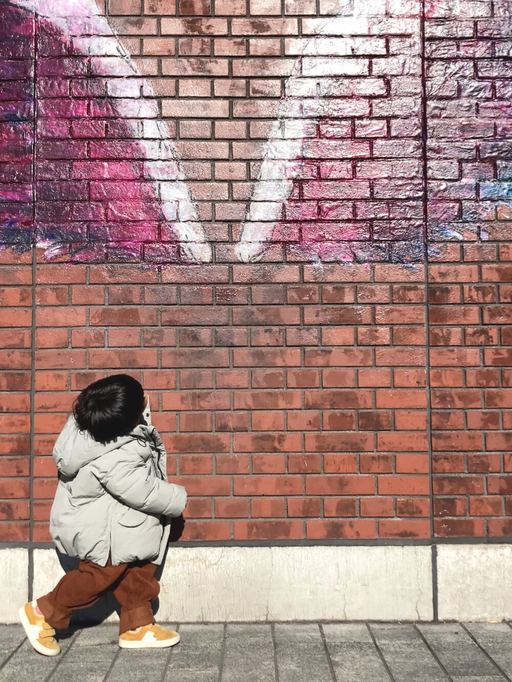 グリーン系のブルゾン、ホワイト系のスウェット、ブラウン系のパンツを着用したキッズの冬コーディネートの4枚目の写真