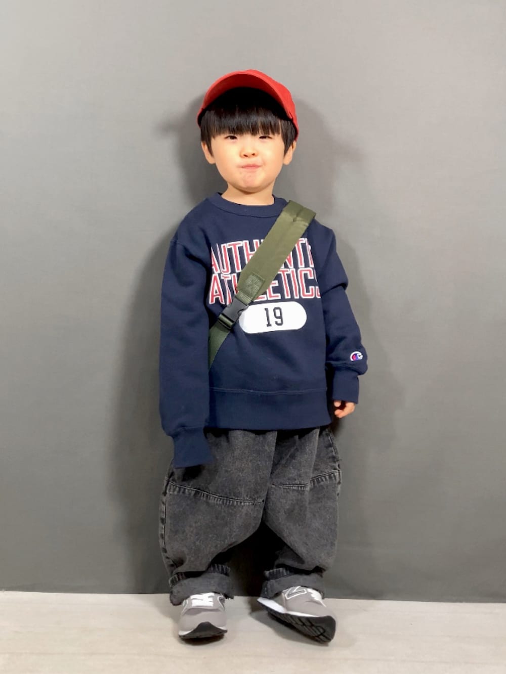 ブルー系のスウェット、ブラック系のデニムパンツ、グリーン系のボディバッグ/ウエストポーチを着用したキッズの春コーディネートの2枚目の写真