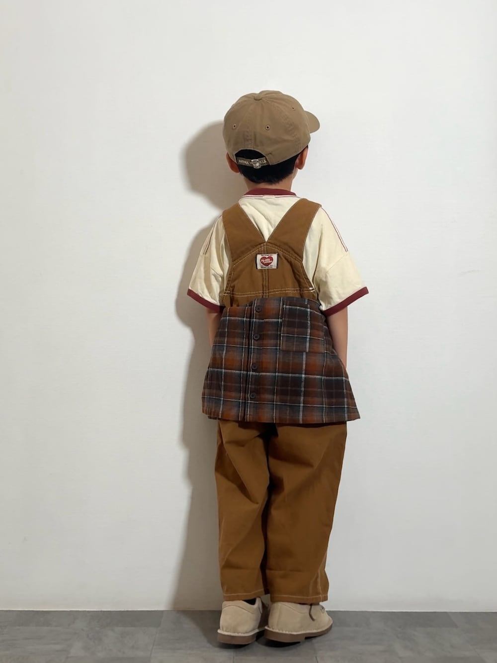 ブラウン系のTシャツ/カットソー、ベージュ系のモカシン/デッキシューズ、オレンジ系のシャツ/ブラウスを着用したキッズの秋コーディネートの3枚目の写真