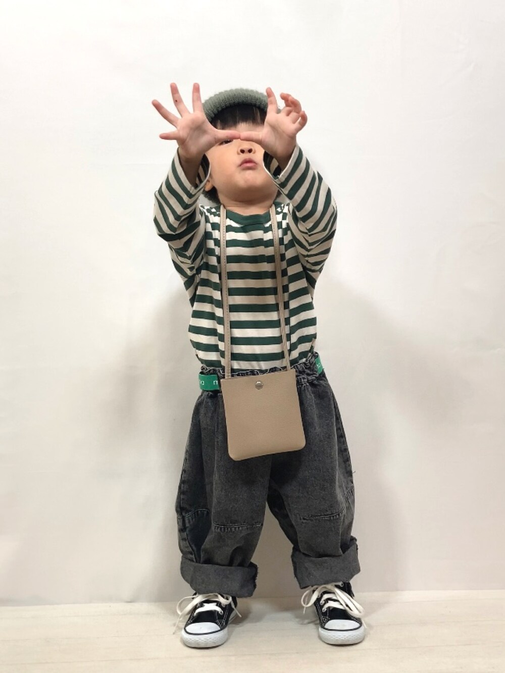 グリーン系のTシャツ/カットソー、ブラック系のデニムパンツ、ベージュ系のショルダーバッグを着用したキッズの夏コーディネートの5枚目の写真
