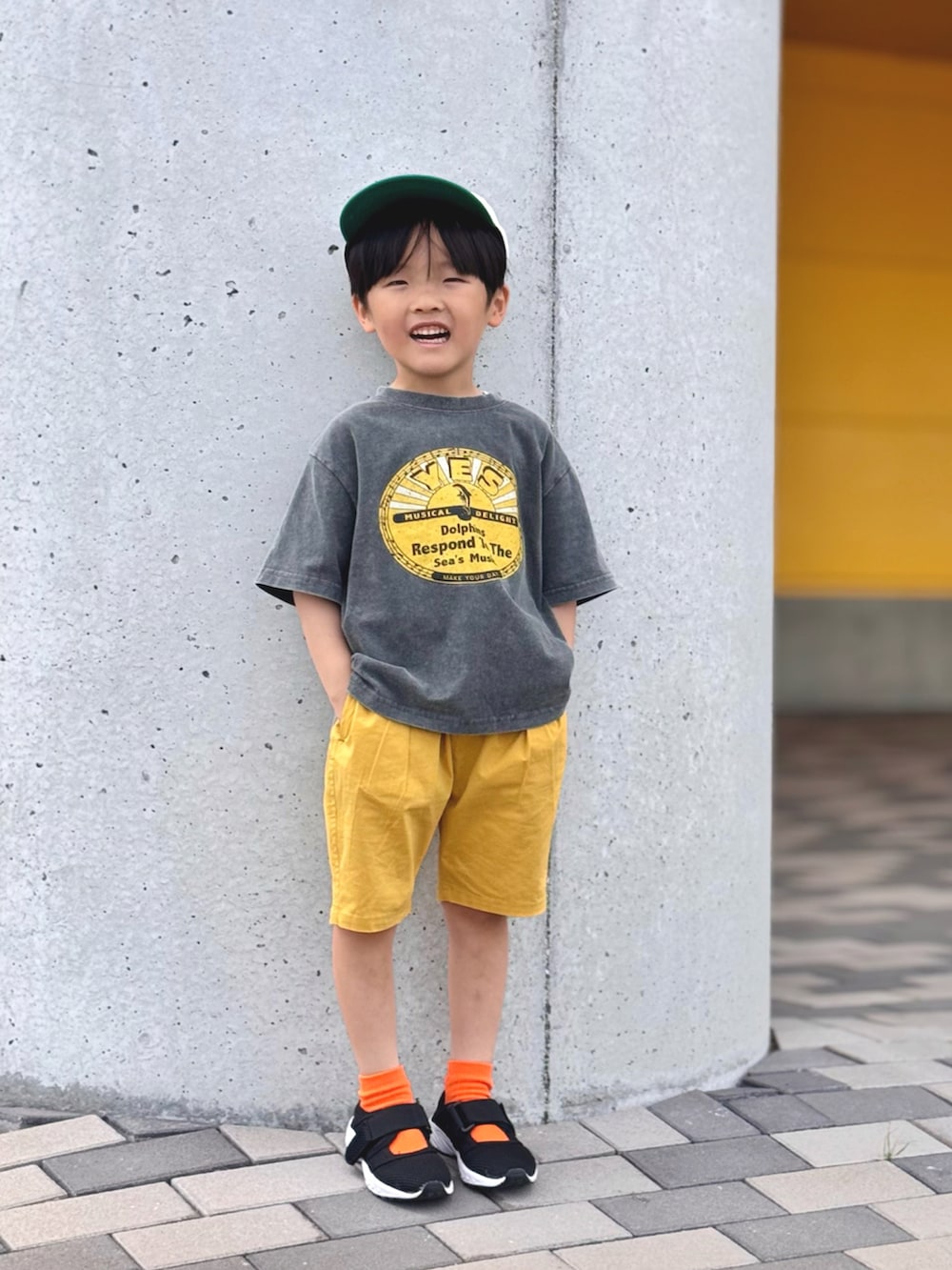 イエロー系のその他パンツ、ブラック系のサンダル、ホワイト系のキャップを着用したキッズの春コーディネートの2枚目の写真