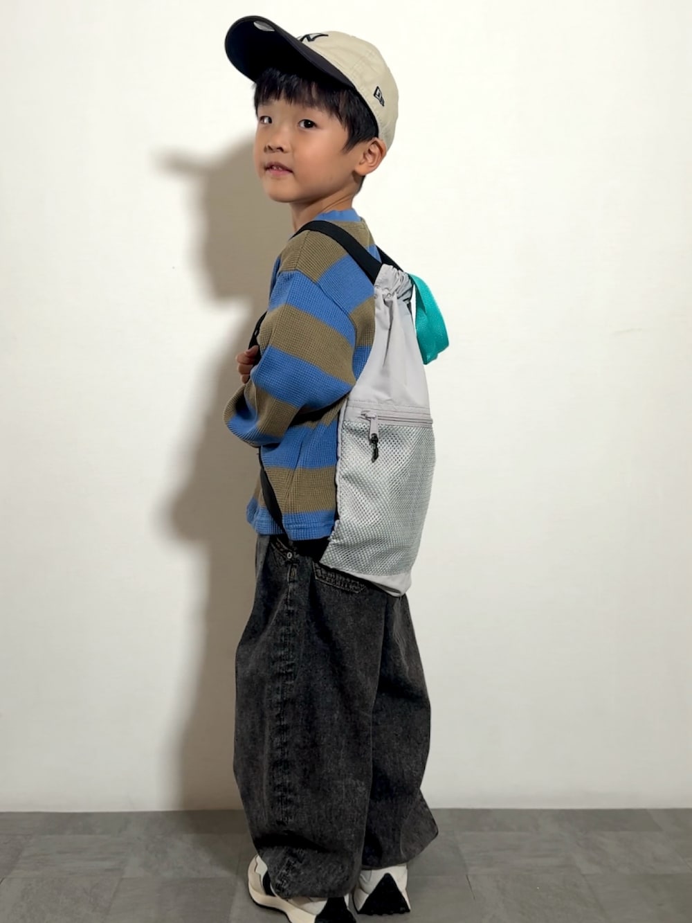 グレー系のバックパック/リュック、ブラック系のその他パンツ、ホワイト系のスニーカーを着用したキッズの秋コーディネートの4枚目の写真