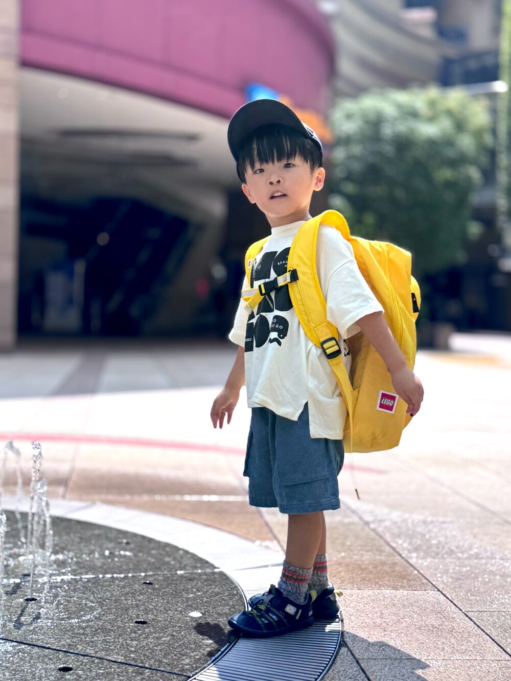 ブラック系のTシャツ/カットソー、ブルー系のその他パンツ、イエロー系のバックパック/リュックを着用したキッズの秋コーディネートの2枚目の写真