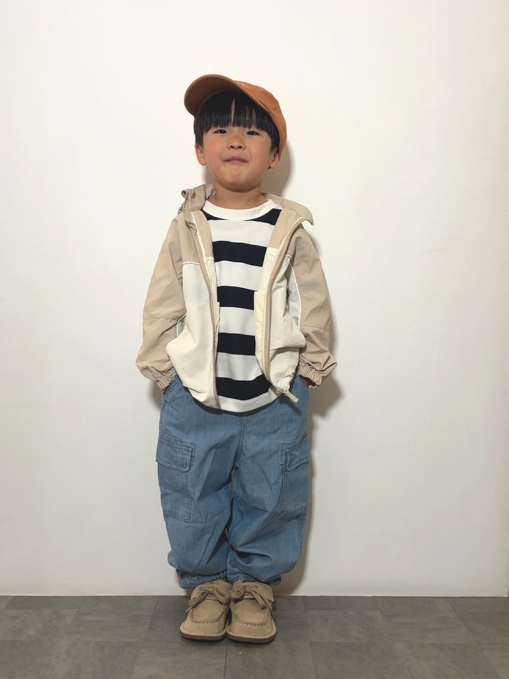 ベージュ系のモカシン/デッキシューズ、ブルー系のTシャツ/カットソー、ベージュ系のジャケット/アウターを着用したキッズの春コーディネートの2枚目の写真