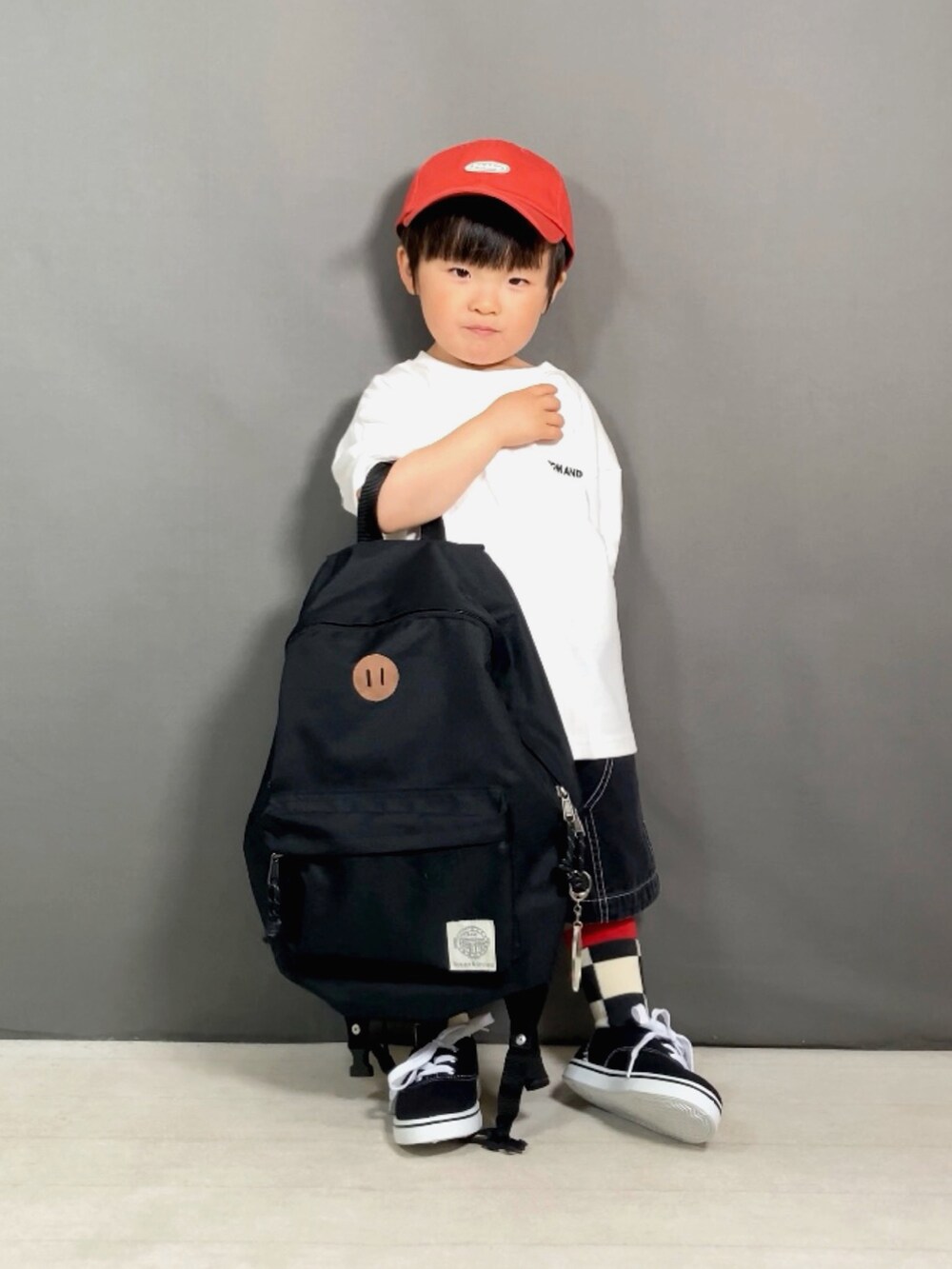 ホワイト系のTシャツ/カットソー、ブラック系のその他パンツ、ブラック系のバックパック/リュックを着用したキッズの春コーディネートの3枚目の写真