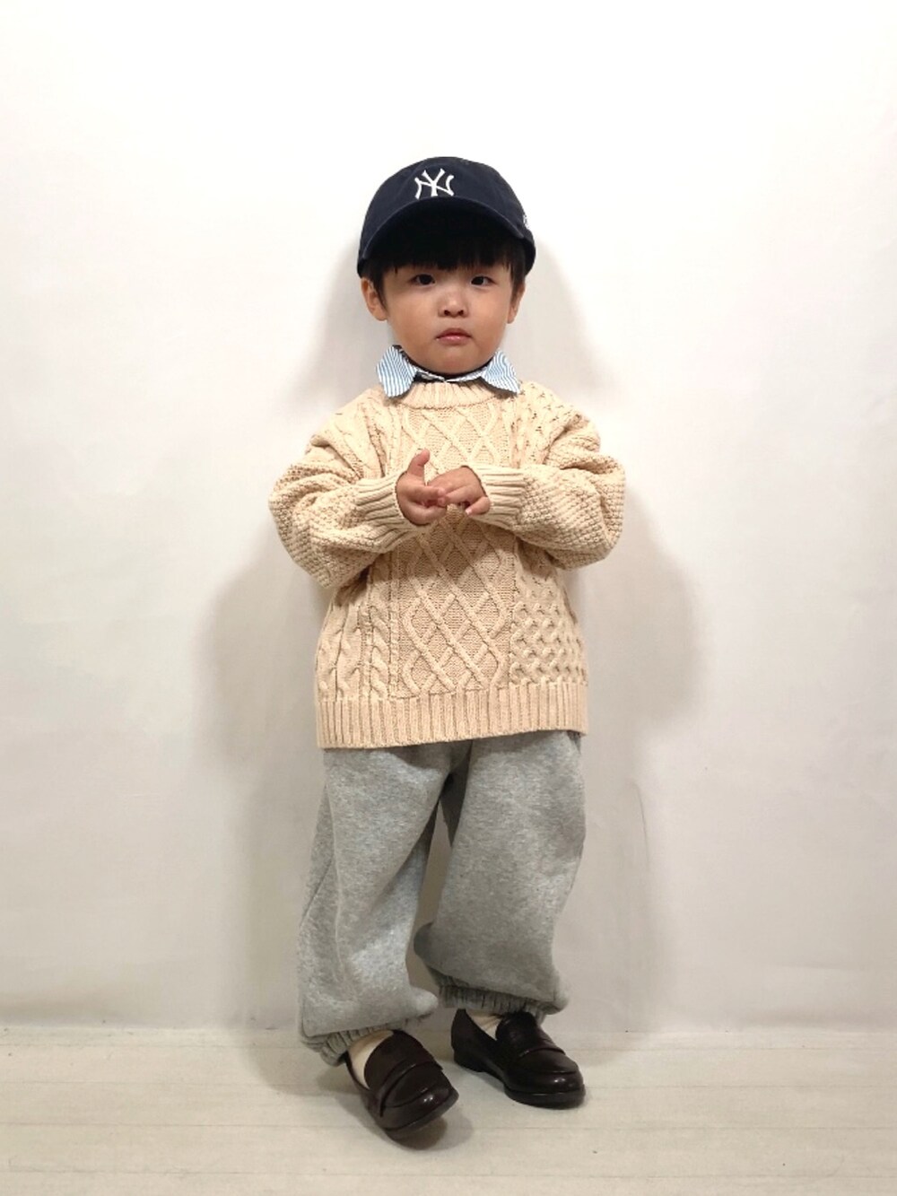 ホワイト系のニット/セーター、ブルー系のシャツ/ブラウス、グレー系のスウェットパンツを着用したキッズの秋コーディネートの2枚目の写真