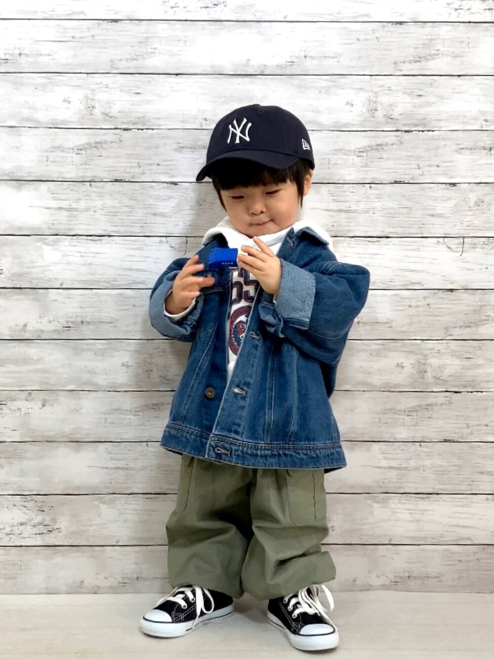 ブルー系のデニムジャケット、ホワイト系のスウェット、グリーン系のカーゴパンツを着用したキッズの冬コーディネートの2枚目の写真