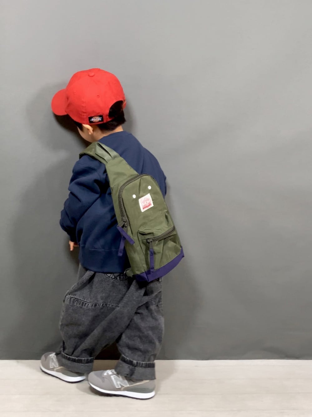 ブルー系のスウェット、ブラック系のデニムパンツ、グリーン系のボディバッグ/ウエストポーチを着用したキッズの春コーディネートの4枚目の写真