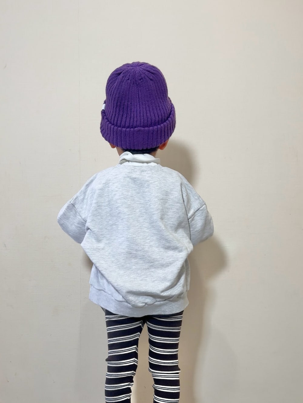 シルバー系のスニーカー、グレー系のショルダーバッグ、ホワイト系のスウェットを着用したキッズの秋コーディネートの3枚目の写真