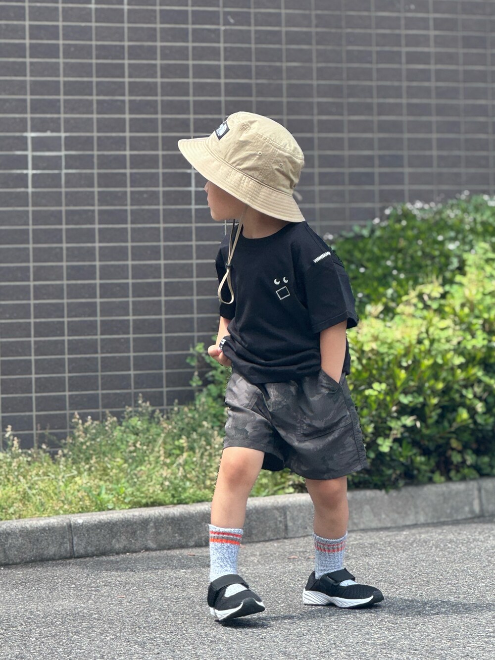 ブラック系のTシャツ/カットソー、グレー系のパンツ、ブラック系のサンダルを着用したキッズの夏コーディネートの3枚目の写真
