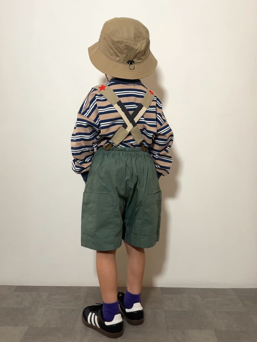 ブルー系のTシャツ/カットソー、ブラック系のスニーカー、グリーン系のその他パンツを着用したキッズの春コーディネートの3枚目の写真