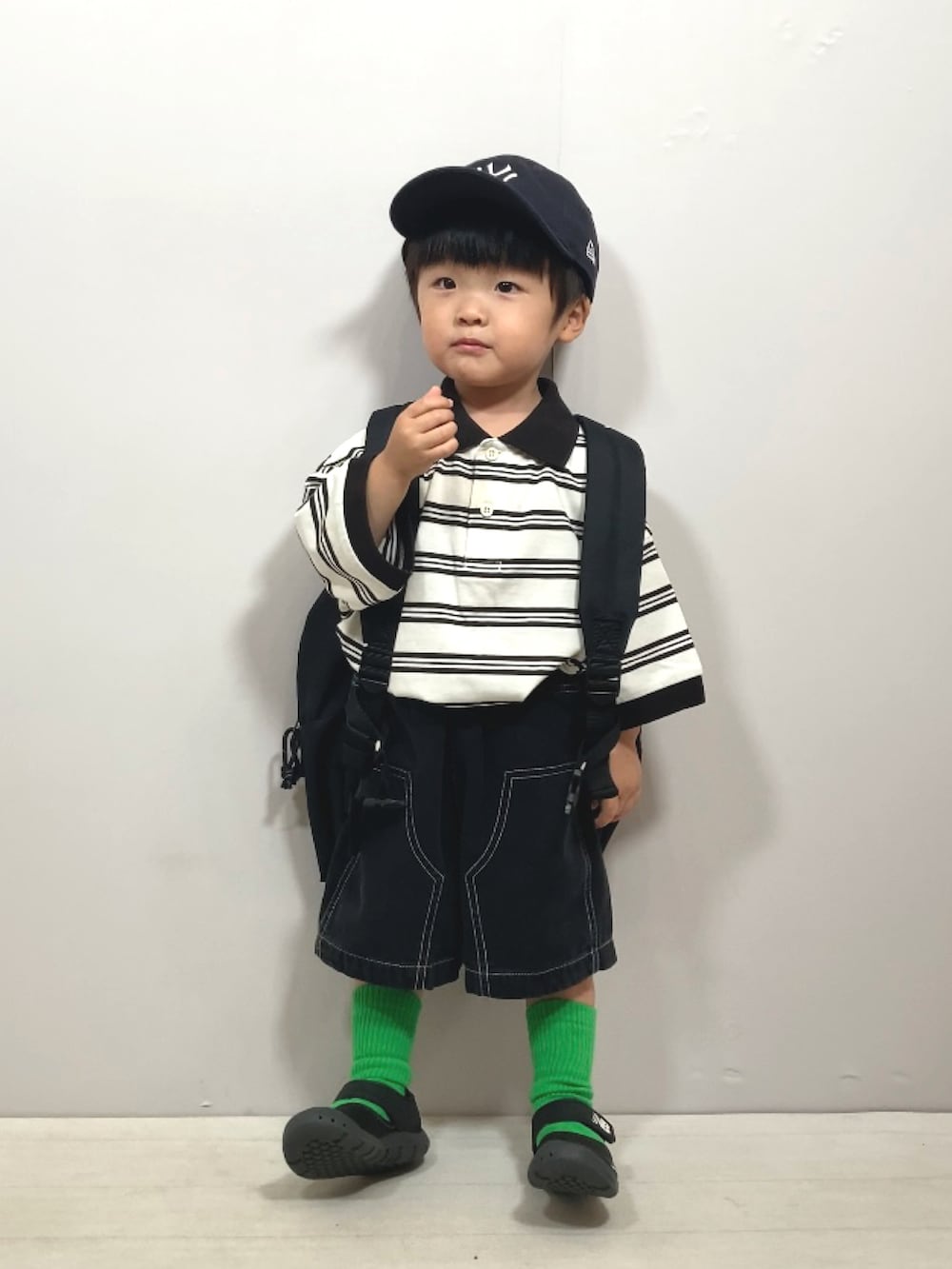 ベージュ系のポロシャツ、ブラック系のその他パンツ、ブラック系のバックパック/リュックを着用したキッズの夏コーディネートの3枚目の写真