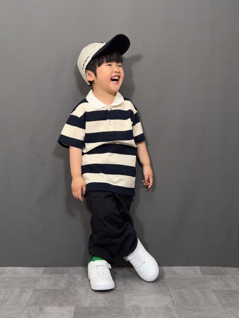 ベージュ系のトップス、ブラック系のパンツ、ホワイト系のショルダーバッグを着用したキッズの春コーディネートの5枚目の写真