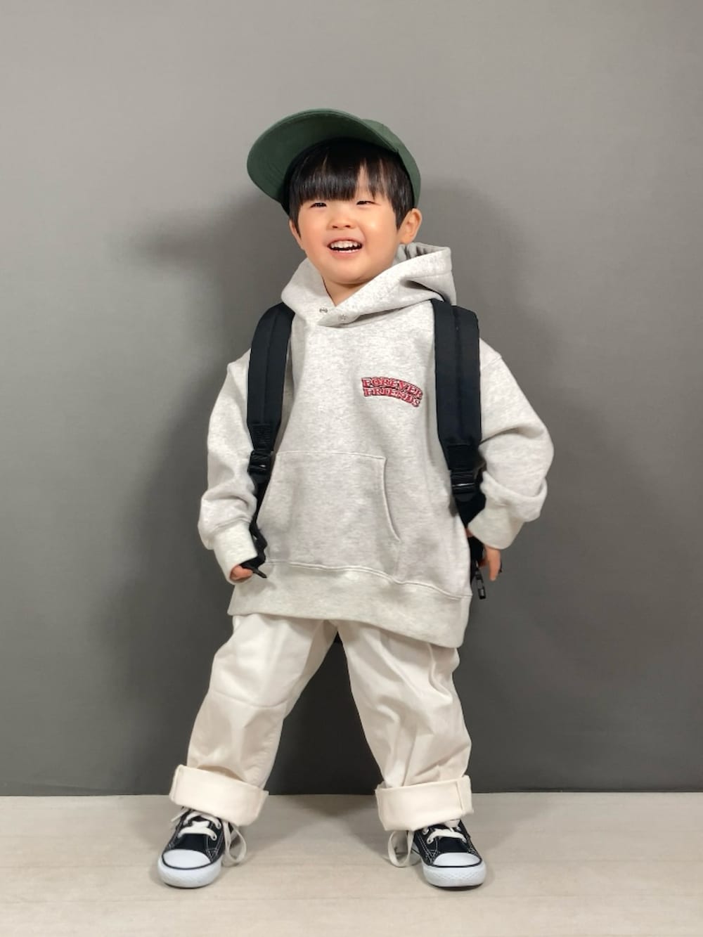 グレー系のスウェット、ホワイト系のパンツ、ブラック系のバックパック/リュックを着用したキッズの春コーディネートの4枚目の写真