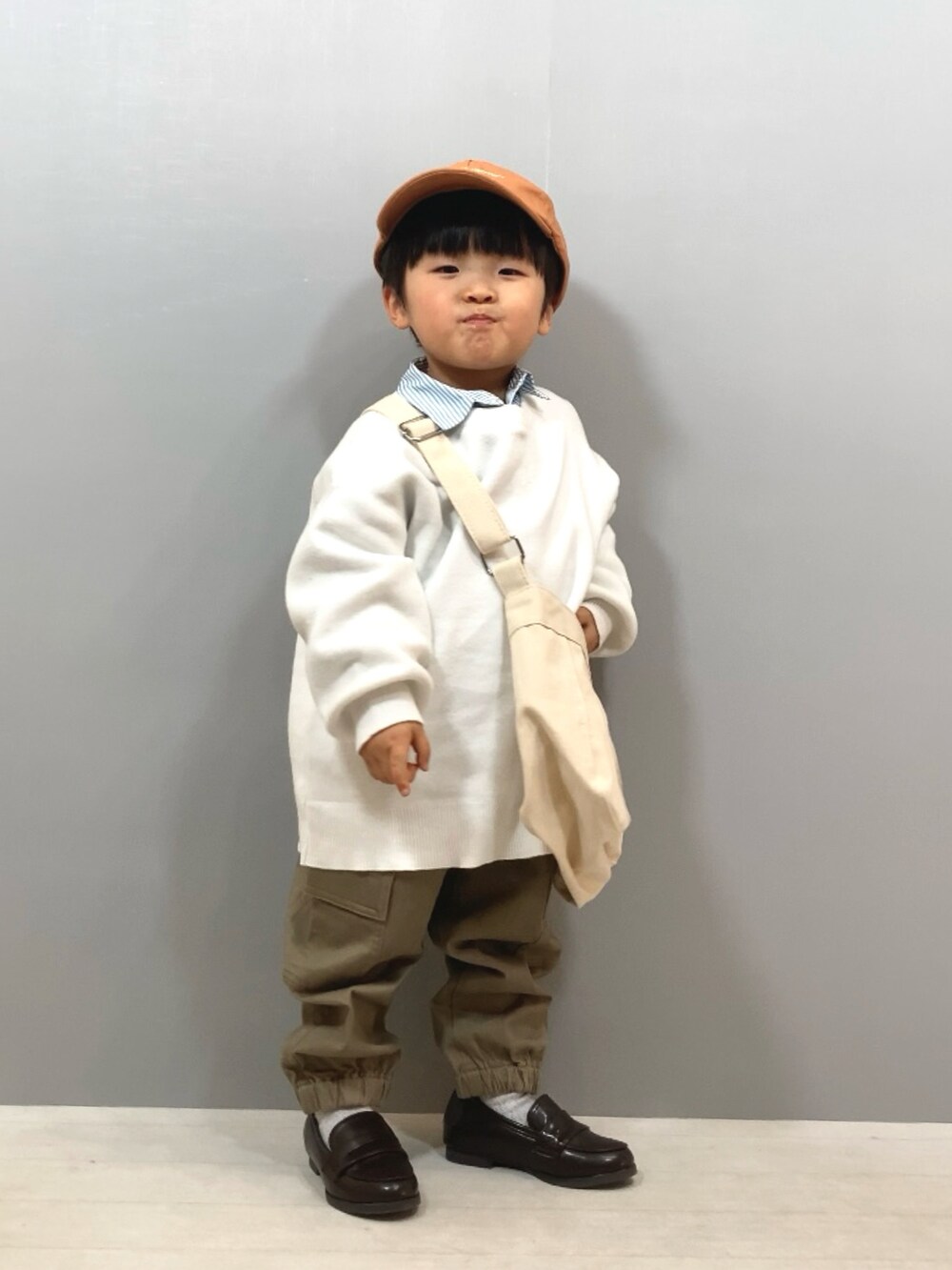ホワイト系のニット/セーター、ブルー系のシャツ/ブラウス、ベージュ系のパンツを着用したキッズの冬コーディネートの2枚目の写真