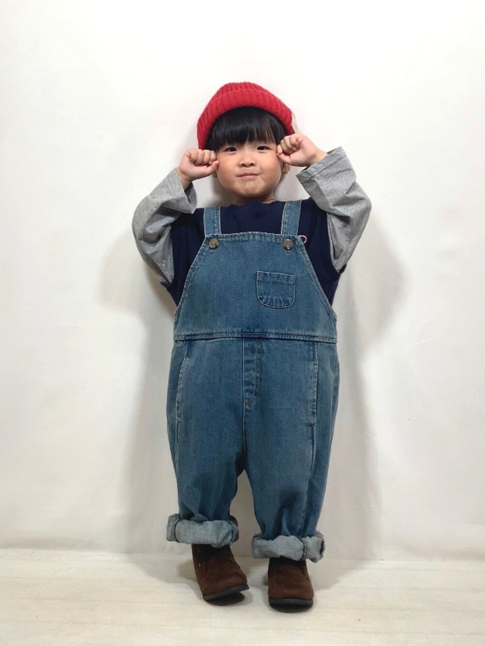 ブルー系のトップス、ブルー系のオールインワン・サロペット、ブラウン系のブーツを着用したキッズの秋コーディネートの3枚目の写真